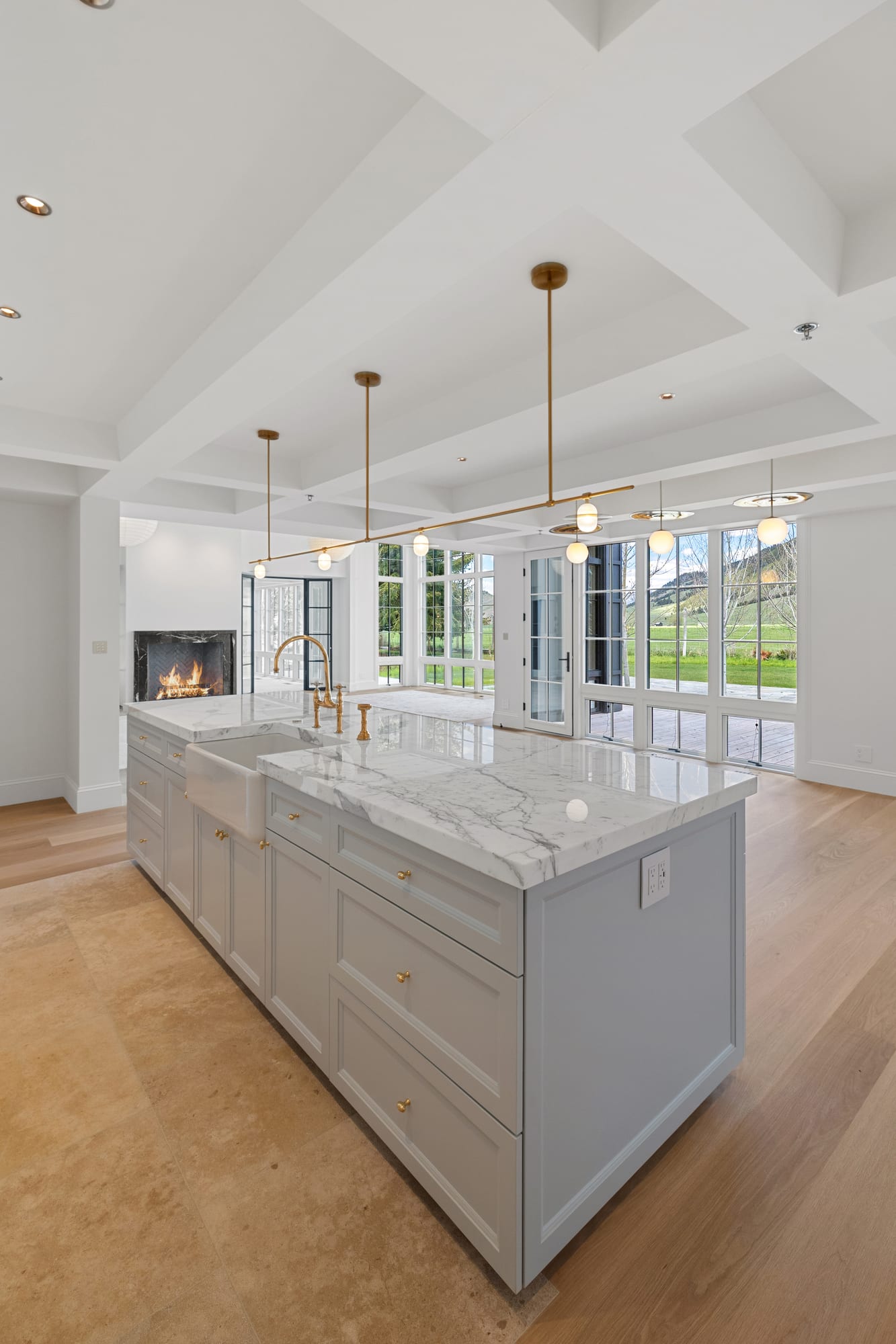 Kitchen looking through the coffered great room to the black marble fireplace.