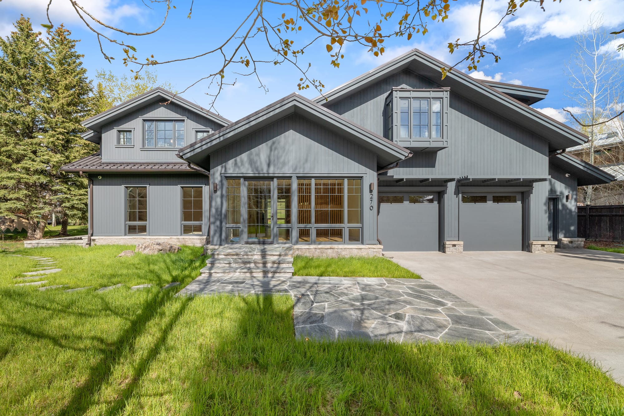 Front approach with flagstone walk and mixed gable roofline.