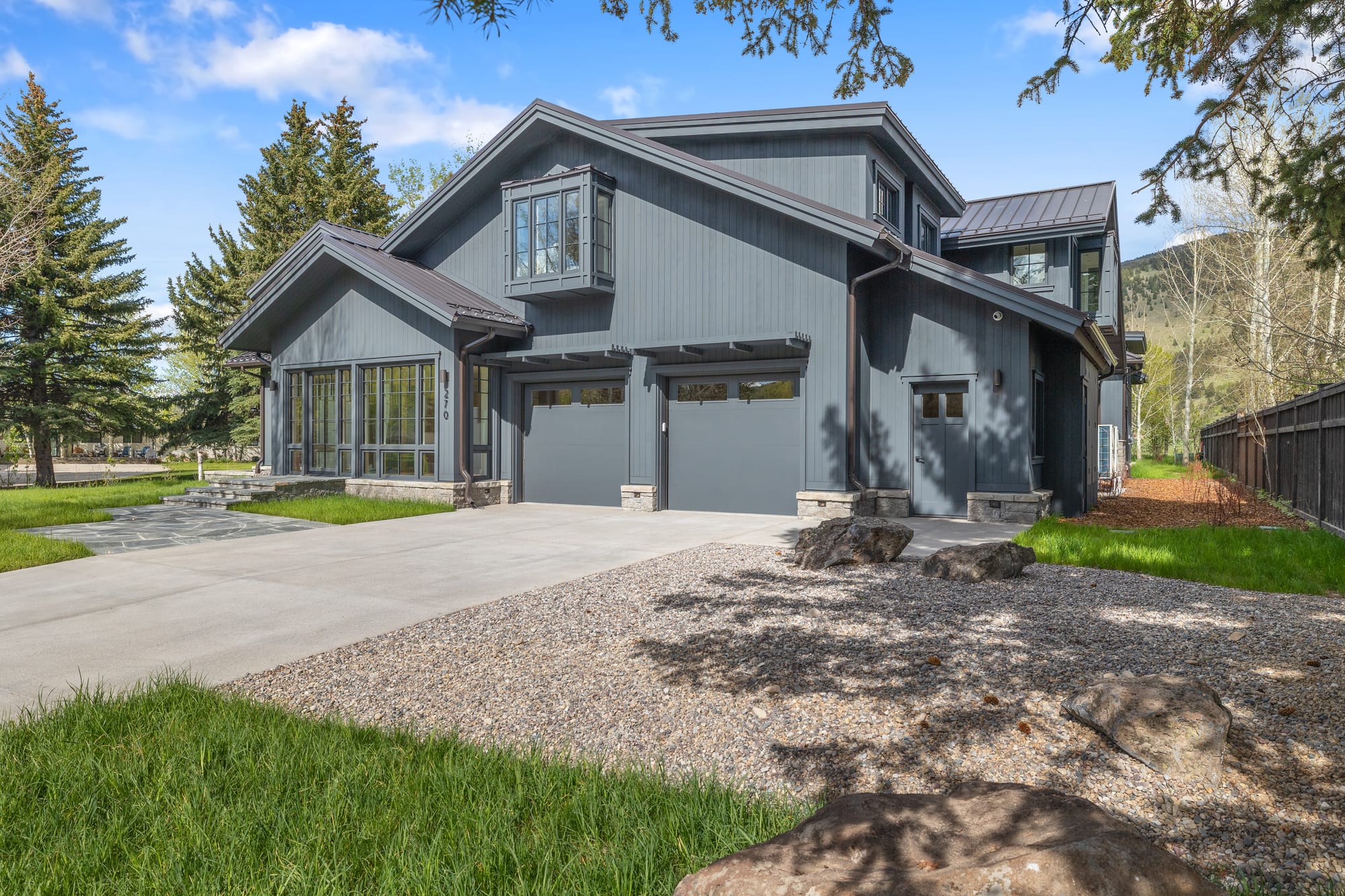 Front elevation with the two-car garage in matching charcoal siding.