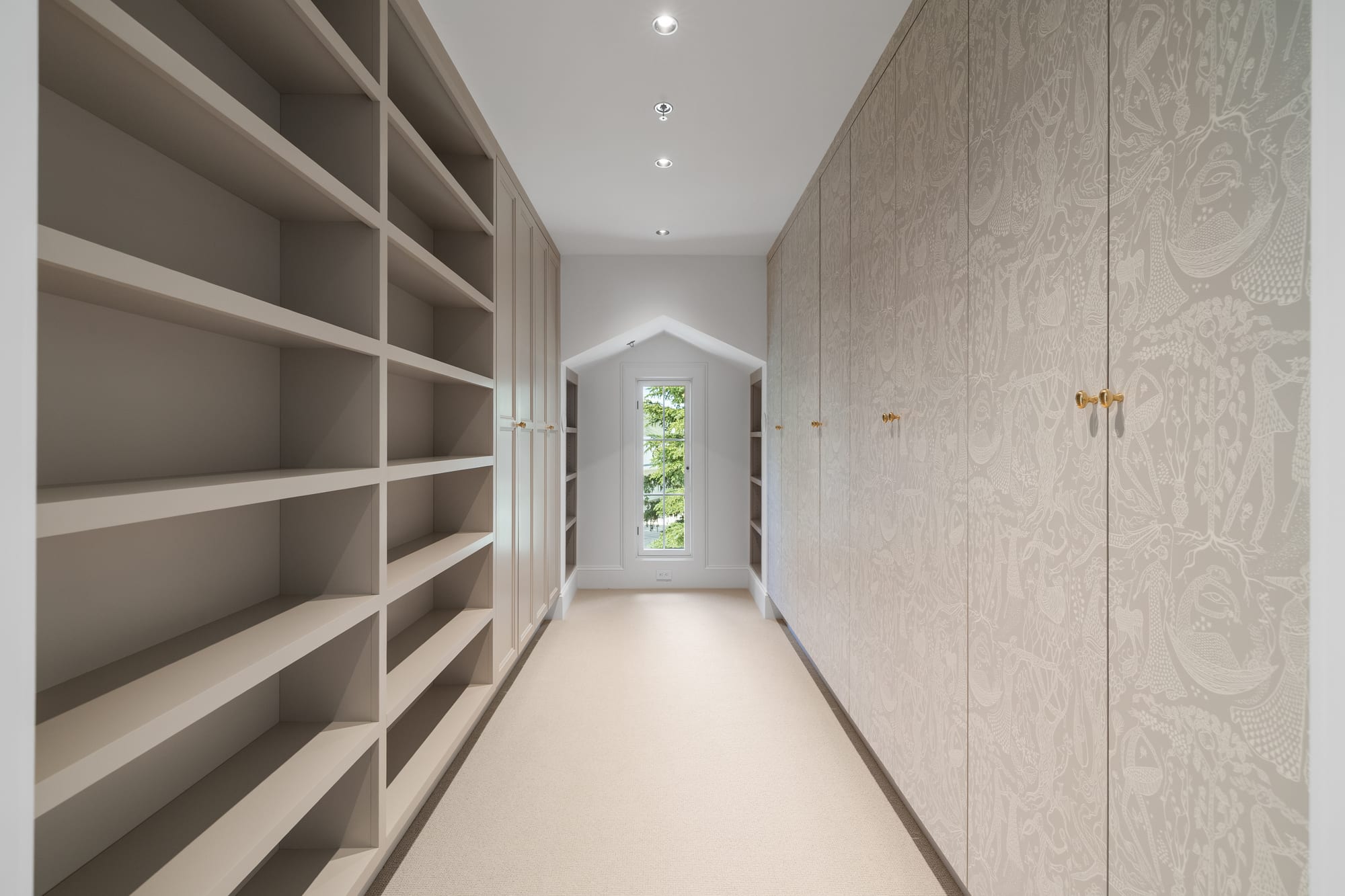 Dressing room with open painted shelving opposite full-height wardrobes.