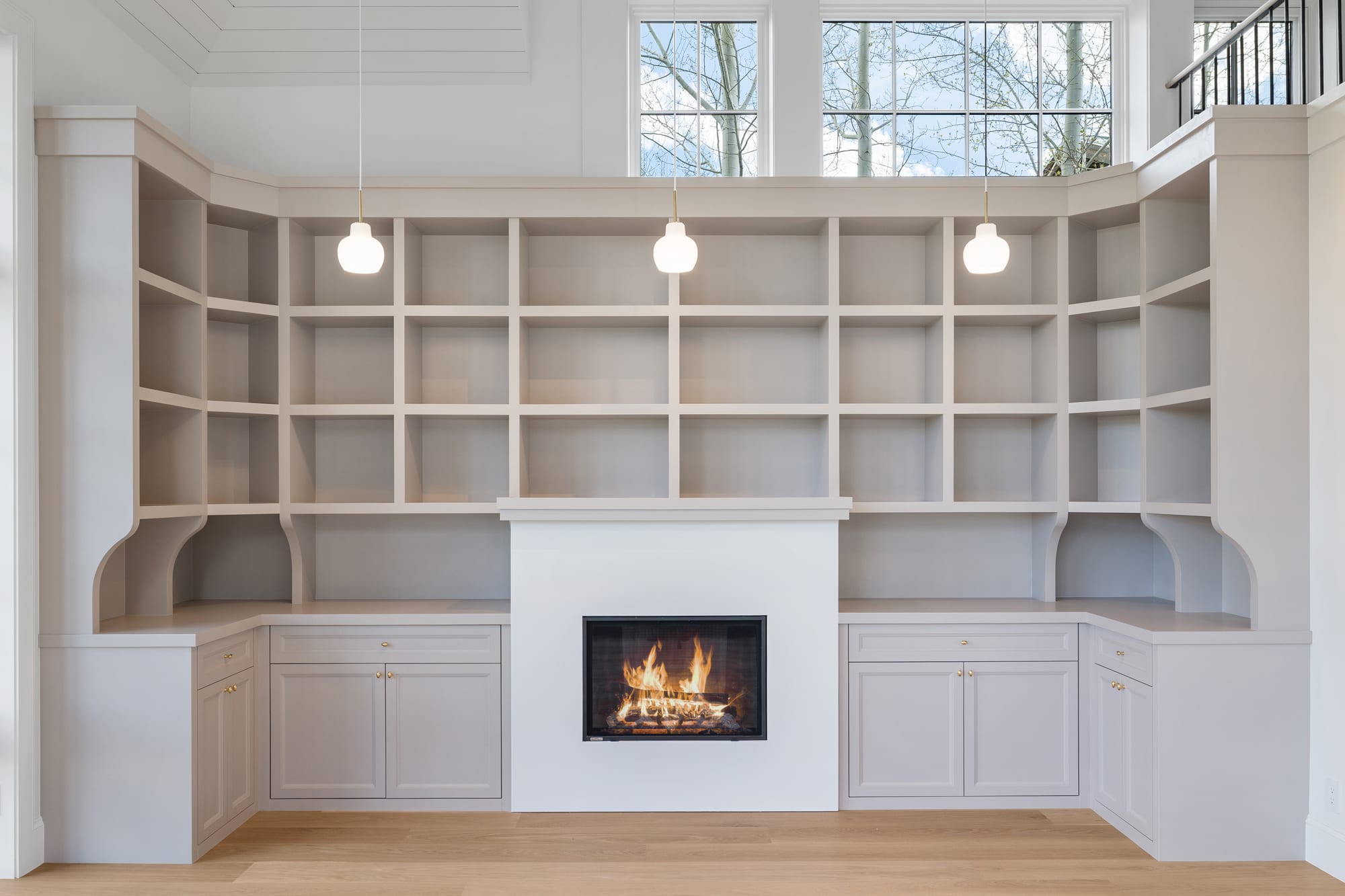 Library: floor-to-ceiling painted shelving wrapping the hearth over base cabinets.