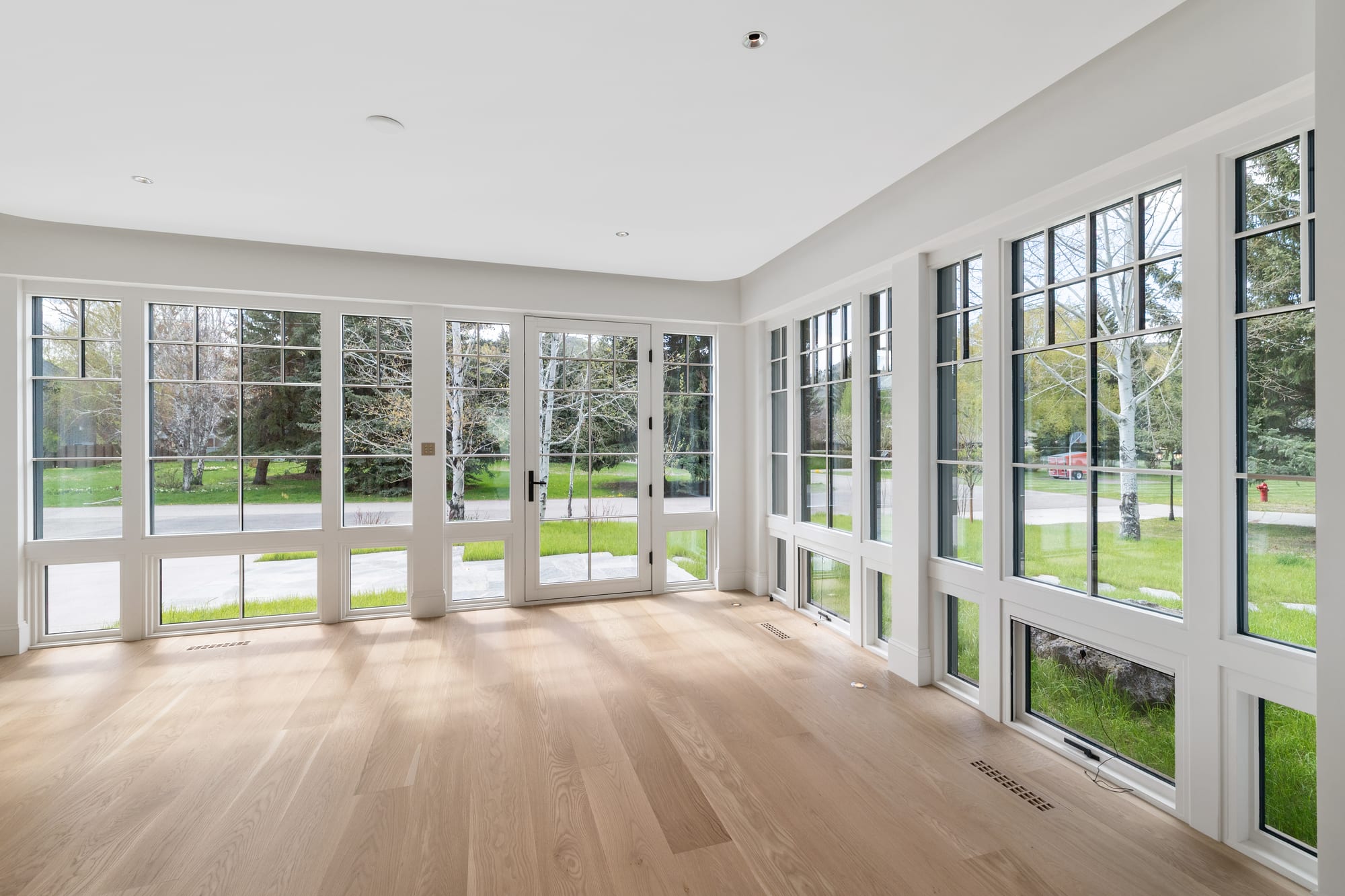 Sun room in white steel windows with white oak flooring and painted trim.